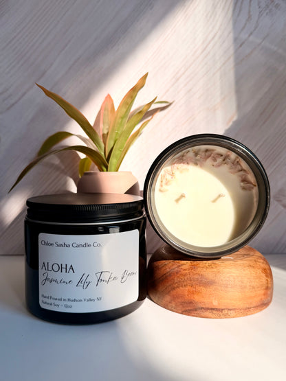 Aloha, floral hand poured natural soy candle. Blooming paradise in a bottle: vibrant flowers and sun-ripened tropics that make every breath feel like a beach getaway. Notes of jasmine, lily &amp; tonka bean. Pearlized white shimmer upon melting.