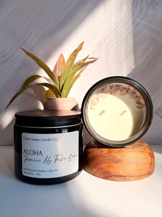 Aloha, floral hand poured natural soy candle. Blooming paradise in a bottle: vibrant flowers and sun-ripened tropics that make every breath feel like a beach getaway. Notes of jasmine, lily &amp; tonka bean. Pearlized white shimmer upon melting.