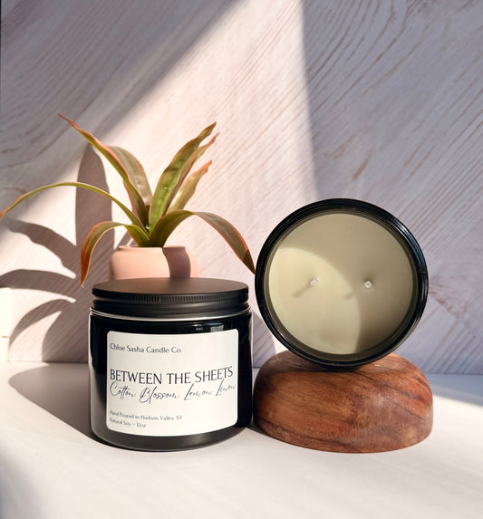 Between The Sheets hand poured natural soy candle. A refined blend of sunlit cotton and cool wind—clean, airy, and effortlessly fresh. Notes of cotton blossom, lemon &amp; linen. Pearlized white shimmer upon melting.