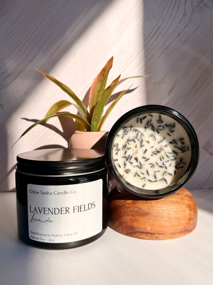 Lavendar hand poured natural soy candle. Lavender Fields captures the essence of this timeless, beautiful flower, beautifully enhanced with bright notes of citrus, camphor, and eucalyptus for a fresh, true-to-life lavender experience, especially enhanced with farm fresh lavender buds added for that extra touch.