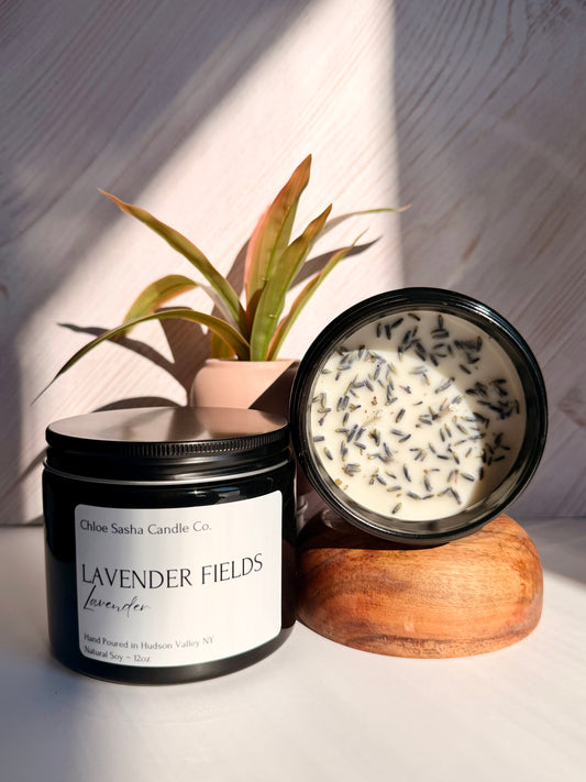 Lavendar hand poured natural soy candle. Lavender Fields captures the essence of this timeless, beautiful flower, beautifully enhanced with bright notes of citrus, camphor, and eucalyptus for a fresh, true-to-life lavender experience, especially enhanced with farm fresh lavender buds added for that extra touch.